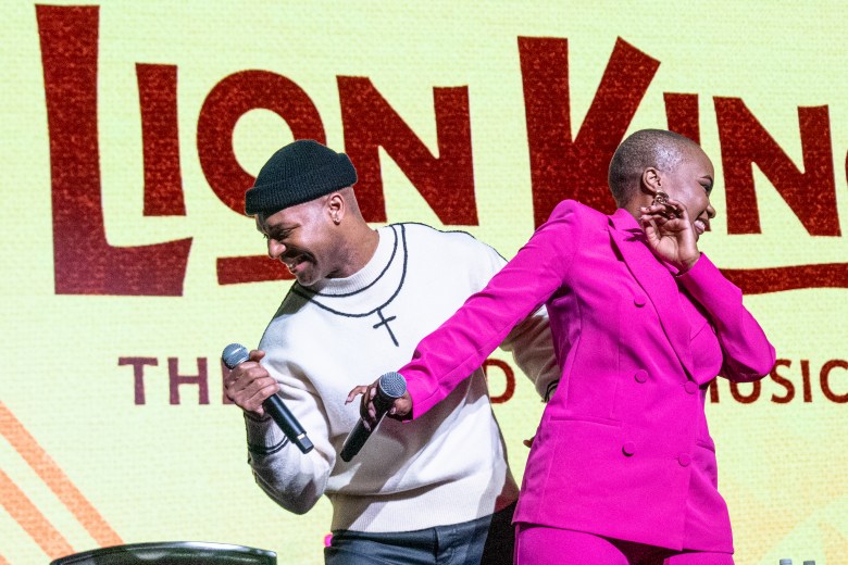 Two cast members of the lion king perform on stage