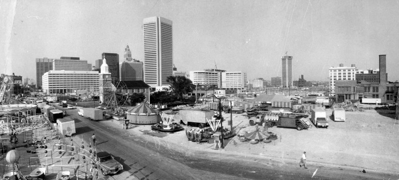 A black and white photograph of the Baltimore City Fair. September 15, 1976-BALTIMORE CITY FAIR--From high on one of the rides this photo shows the full 27 acre site of the City Fair that opens at noon Friday. That's Otterbein Church on Sharp street at left center. Photo by Sun photographer Irving Phillips. AHF-429-BS