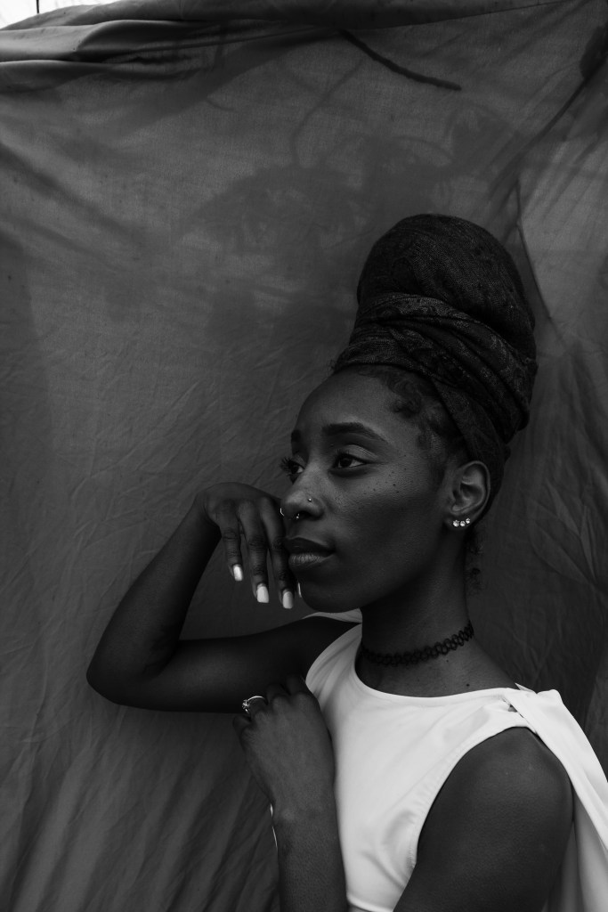 Black and white photograph of a person with brown skin
