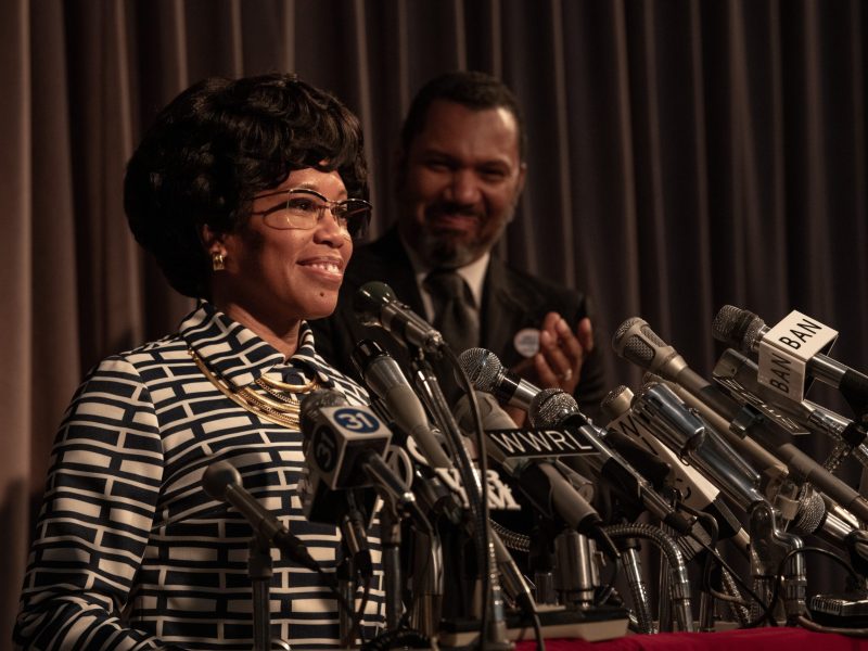 Photograph of two figures with brown skin at a podium.