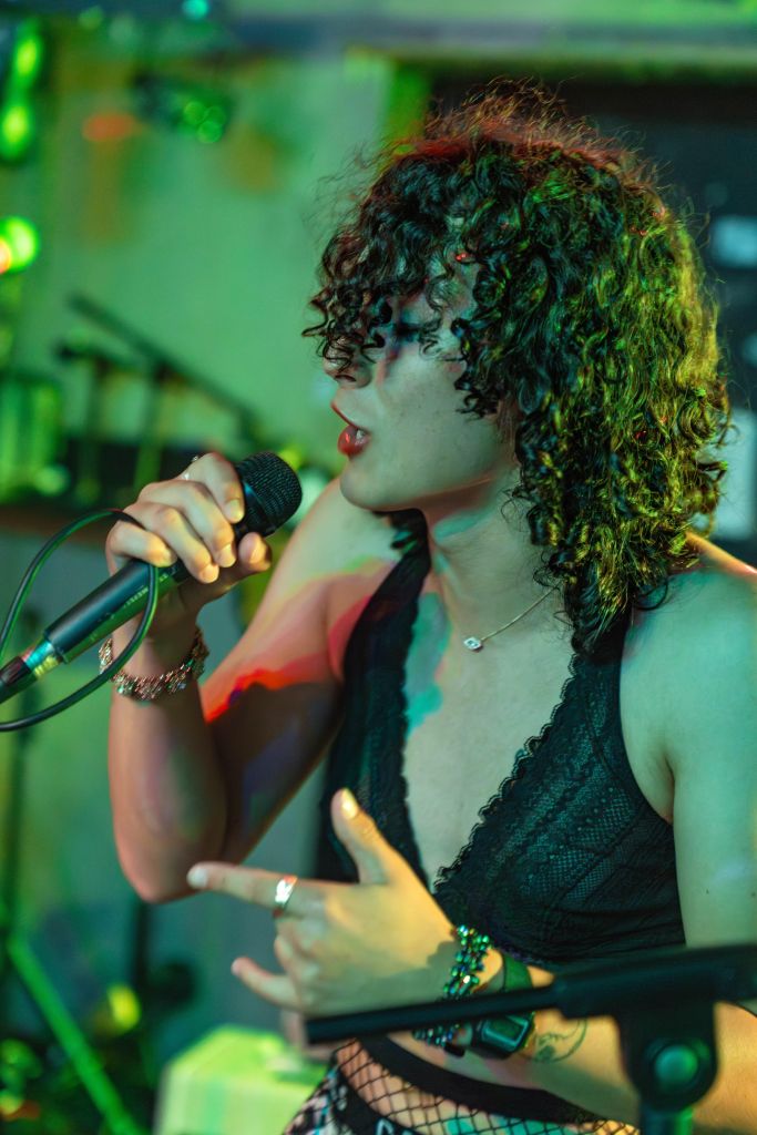 Photo of a person with brown skin, curly hair performing.