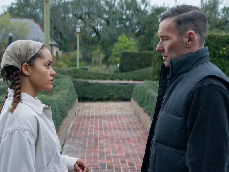Quintessa Swindell as Maya Core and Joel Edgerton as Narvel Roth in Paul Schrader’s “Master Gardener.” (2022). The figures, one male and one female are looking at each other in a garden.