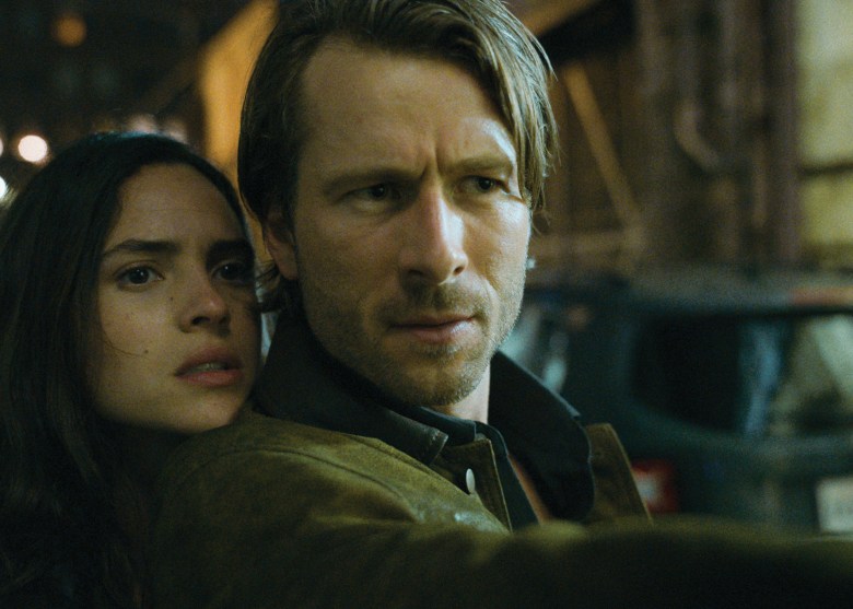 A still from a film. Two people are looking into the distance.
