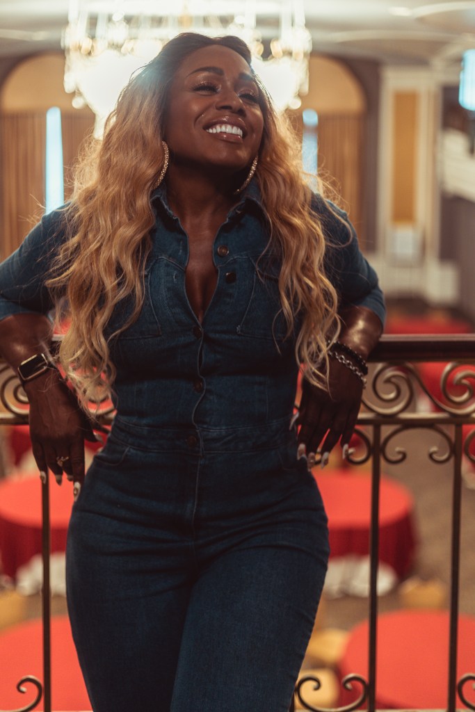 A woman with brown skin smiles.