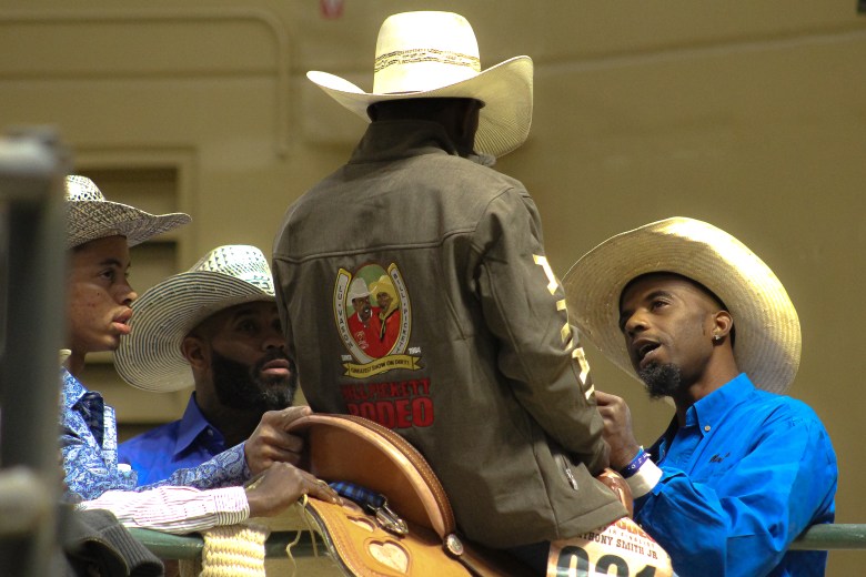 Cowboy Anthony Smith jr. gets a pep talk in the arena before competing from three older cowboys.