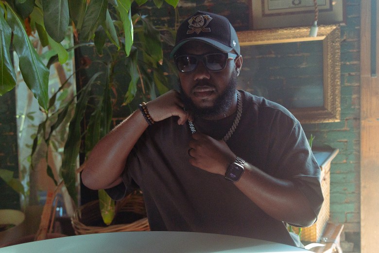 A man with brown skin poses for the camera