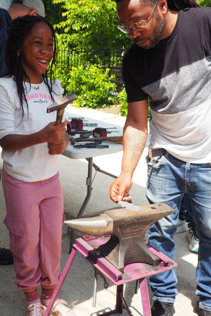 Father and daughter engraving a metal aluminum leaf that will later be added to the gates of The Urban Oasis.