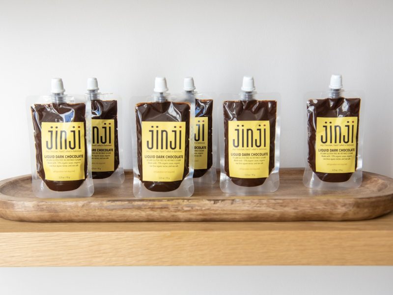 Row of liquid dark chocolate on display.
