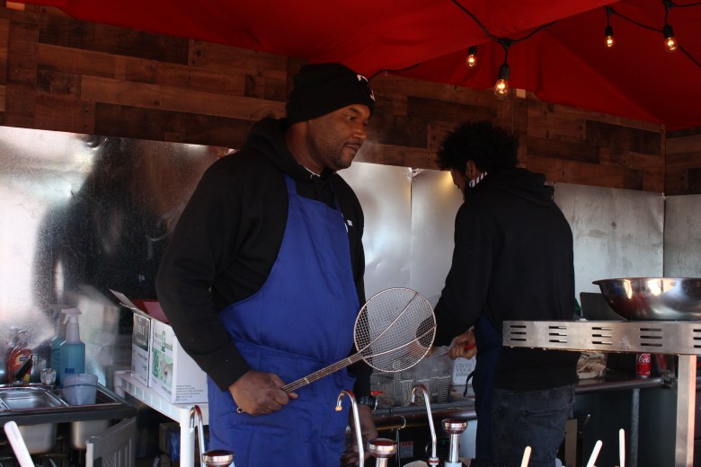 A vendor prepares food at for visitors.