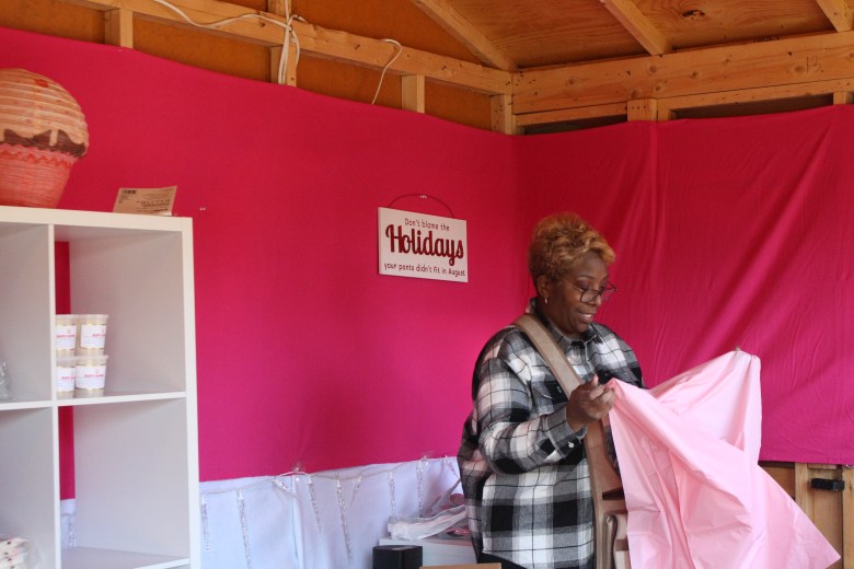 A woman prepares objects and wares for sale at her both at the Baltimore Christmas Village. 