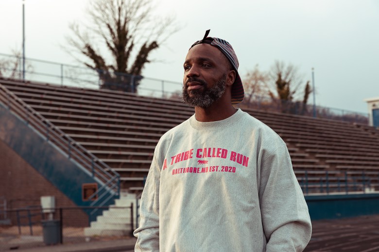 William Walker, founder of A Tribe Called Run. Photo by Schaun Champion. He has brown skin and is wearing a backwards hat and a sweatshirt with "a tribe called run" printed in pink letters.