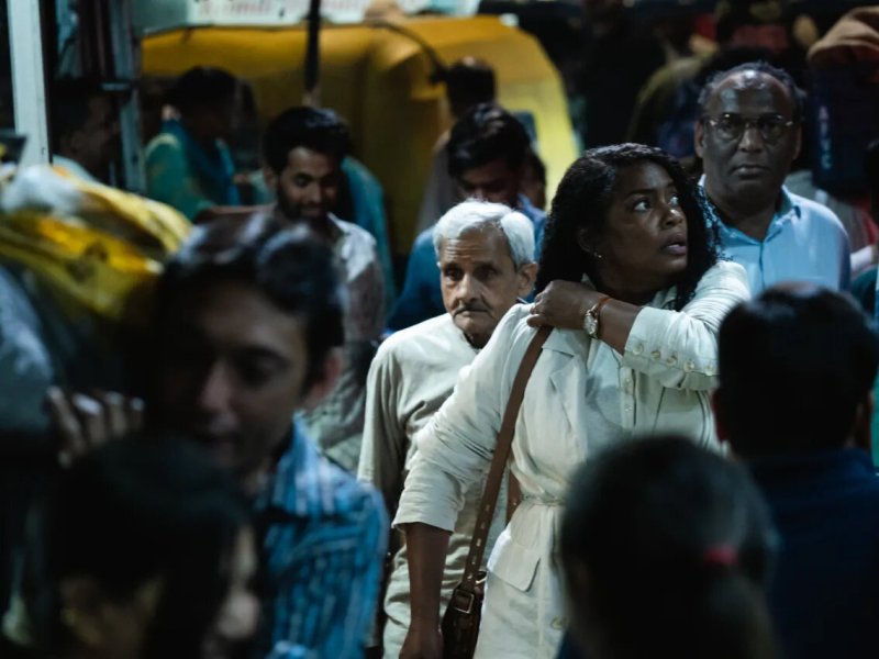 Aunjanue Ellis-Taylor as writer Isabel Wilkerson in Ava DuVernay’s “Origin.” A still featuring a crowd of people.