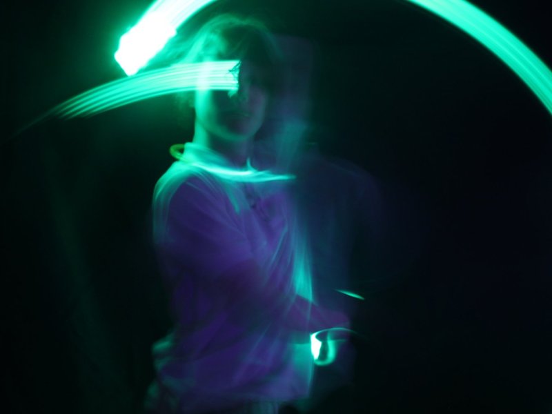 A photo of a young person surrounded by neon green light