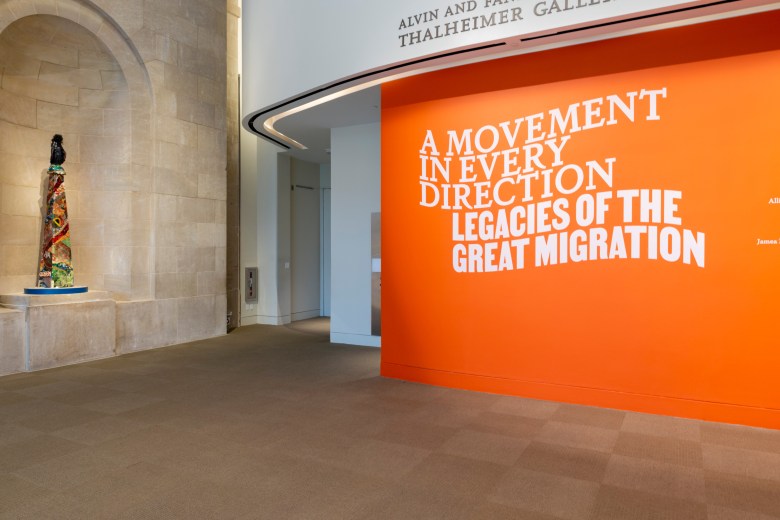 A photograph of the Baltimore Museum of Art, there is an orange wall with white text that says "A movement in every direction legacies of the great migration."