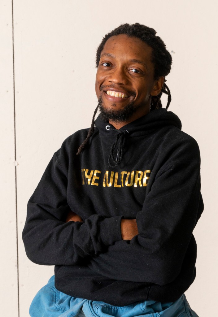Photo of a person with brown skin smiling.