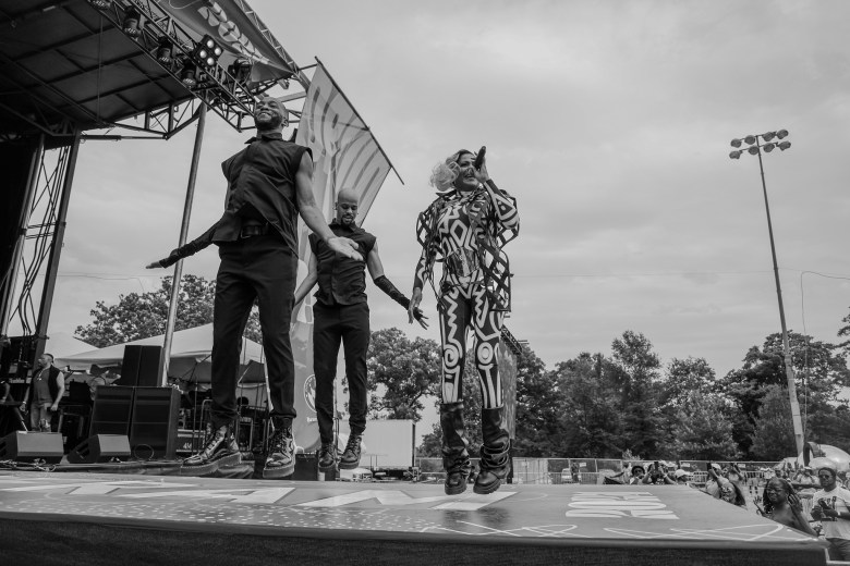 a black and white photo of three people performing on a stage
