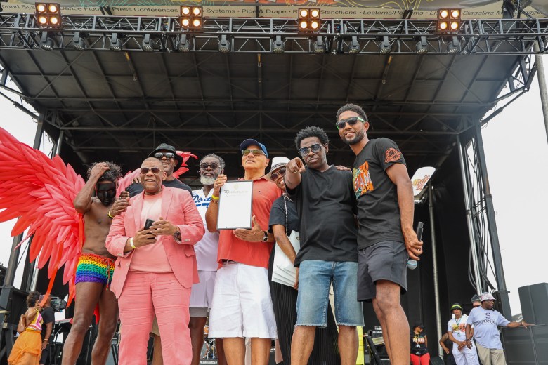 A group of musicians and dancers on stage with the mayor of baltimore