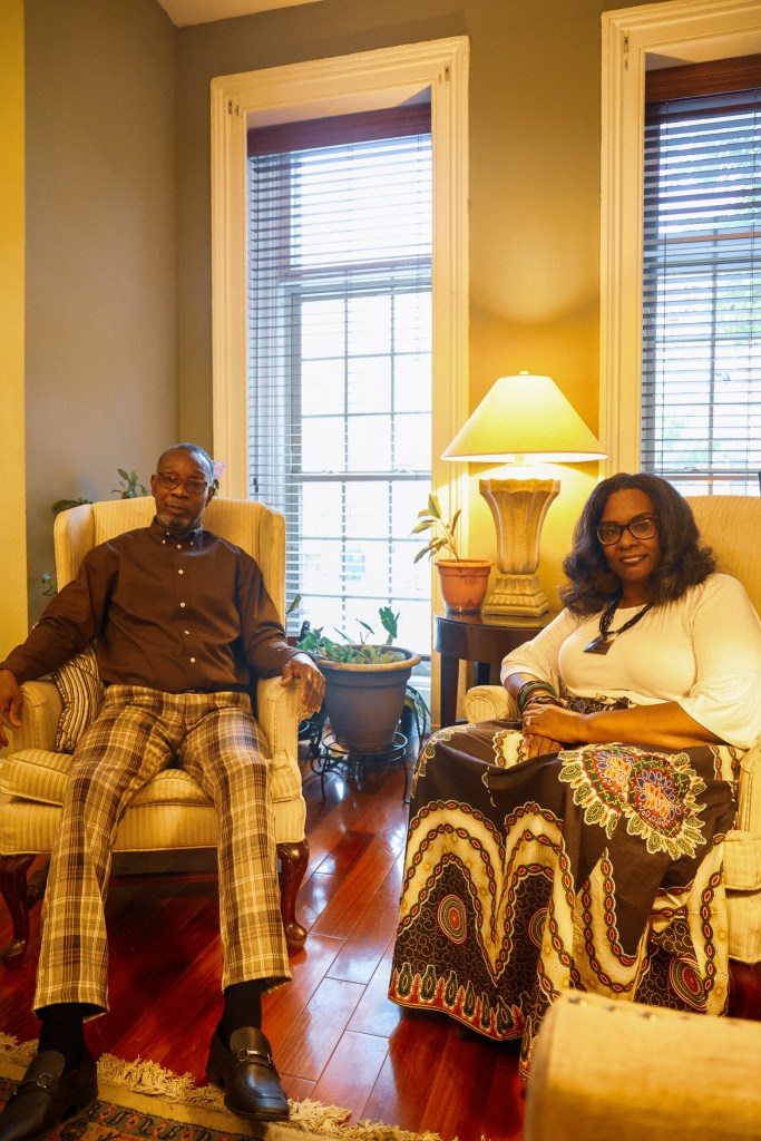 Two people sit in a living room.