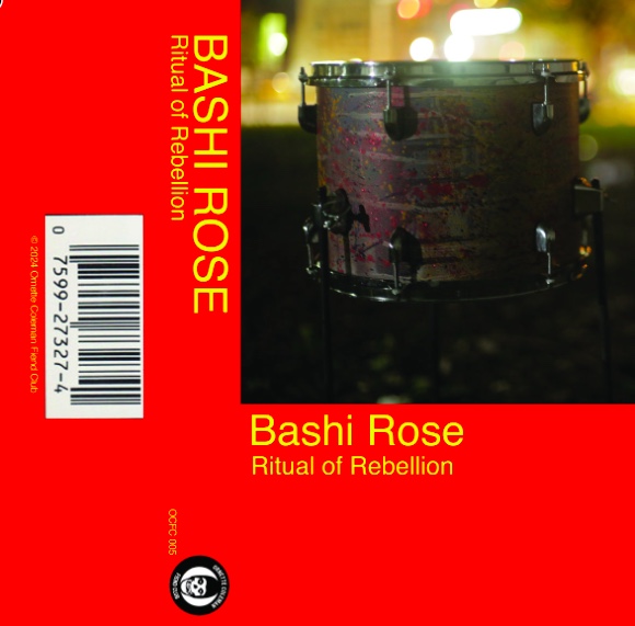 An image of cover art. It's a red square with the words "Bashi Rose Ritual of Rebellion" written in yellow text. There is also a picture of a drum.