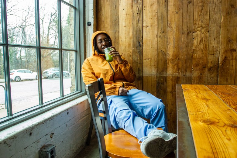 a person with brown skin sits in a matcha store 
