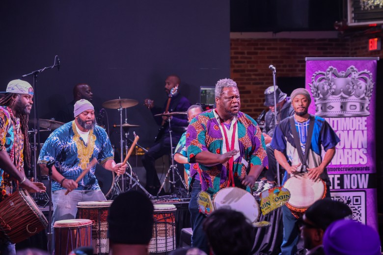 photo of a group of people performing with drums 