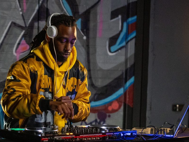 A dj plays in a colorful room.