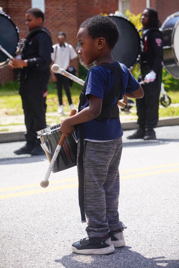 A young boy holds a drum 

