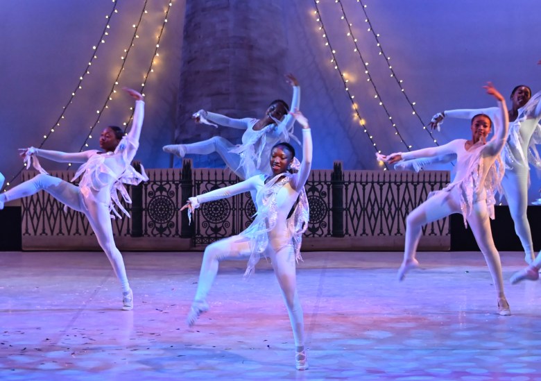 Dancers on stage dressed all in white.