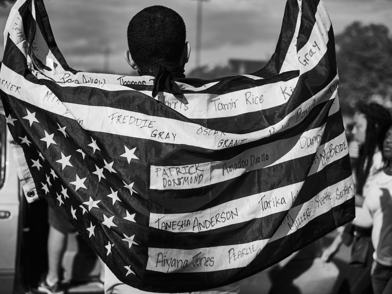 A picture of a man with an American flag draped around his shoulders.