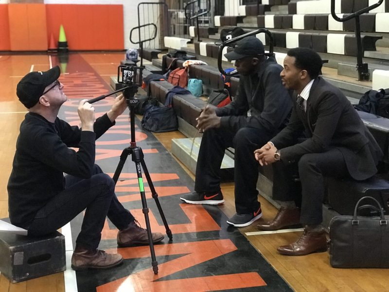 Color still of Director Steven Soderbergh films a scene (using an iPhone) featuring actors Bill Duke and André Holland.