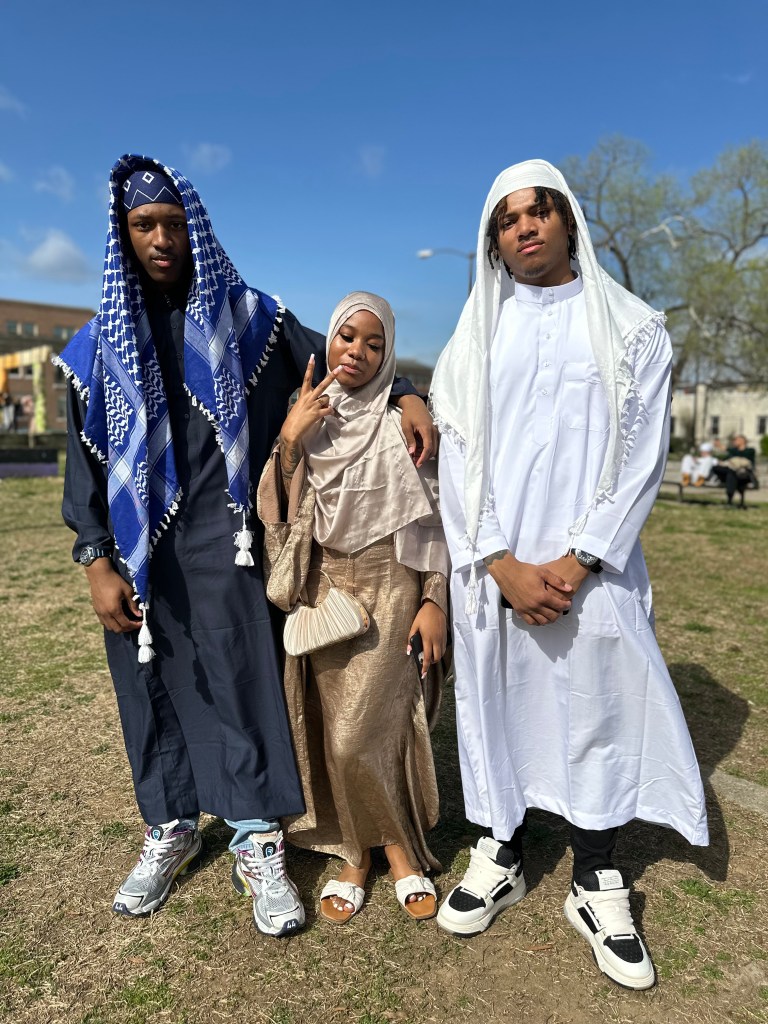 Three cool looking people pose for a picture.