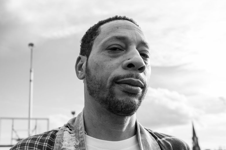 A close up photo of a man, staring not the camera.