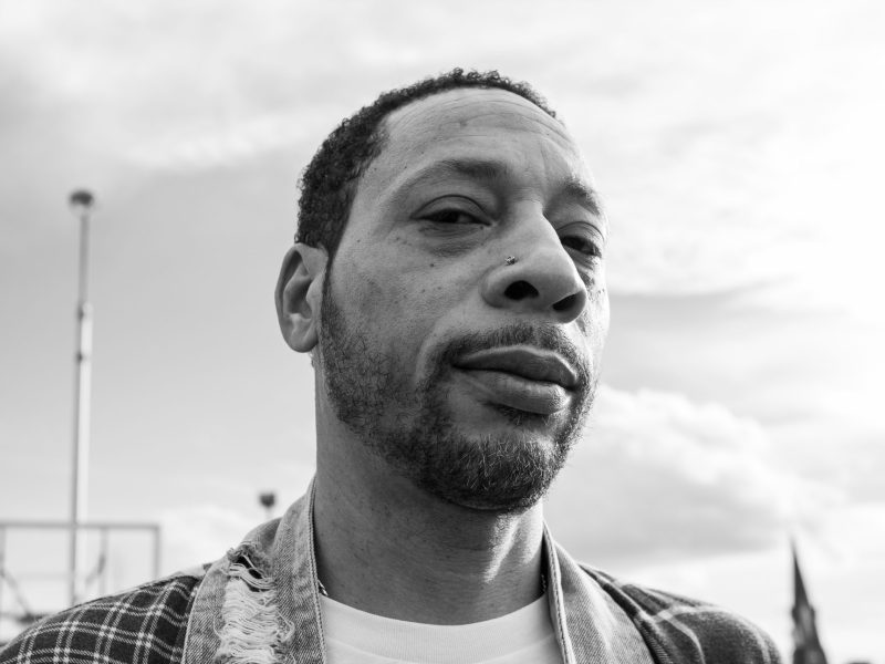 A close up photo of a man, staring not the camera.