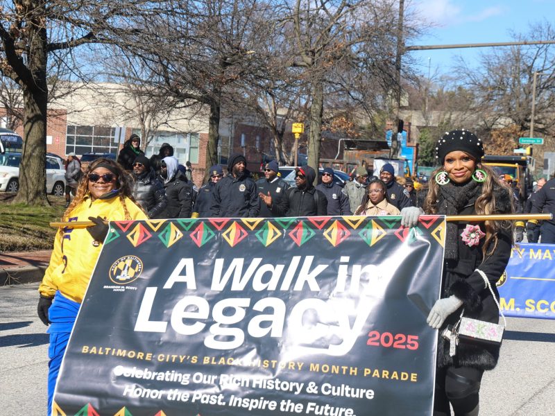 People walk holding a banner that reads "A walk in legacy"