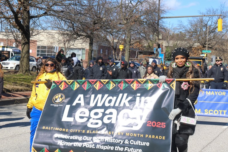 People walk holding a banner that reads "A walk in legacy"