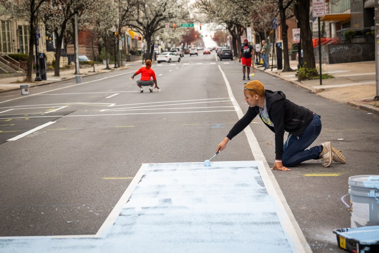 A person paints on the street.