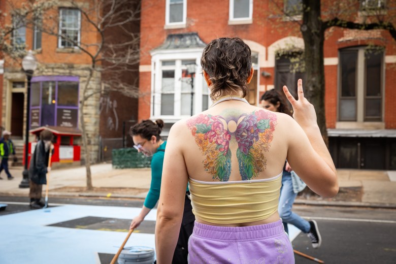 A person's back with a colorful butterfly tattoo.