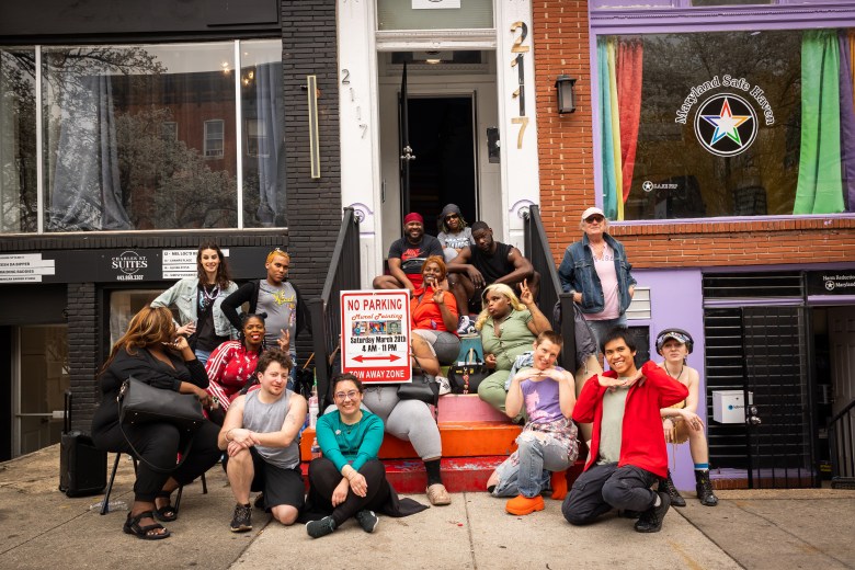 A group of people pose and smile outside the Maryland Safe Haven building.