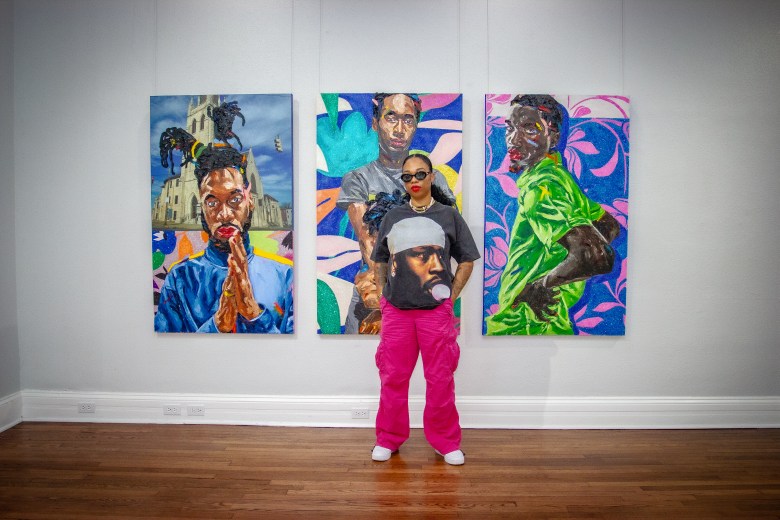 color photo of an artist standing before three of her paintings.