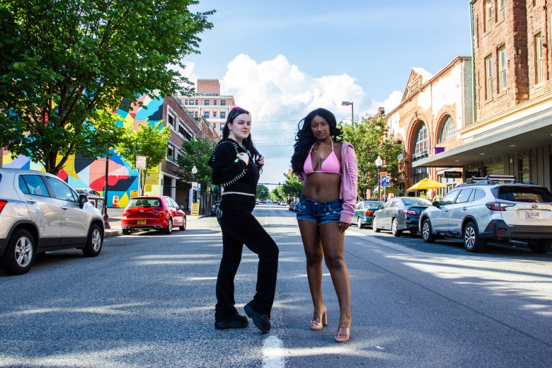 Two people posing in a street. 