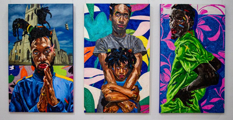 Installation view of three mixed media paintings on a wall.