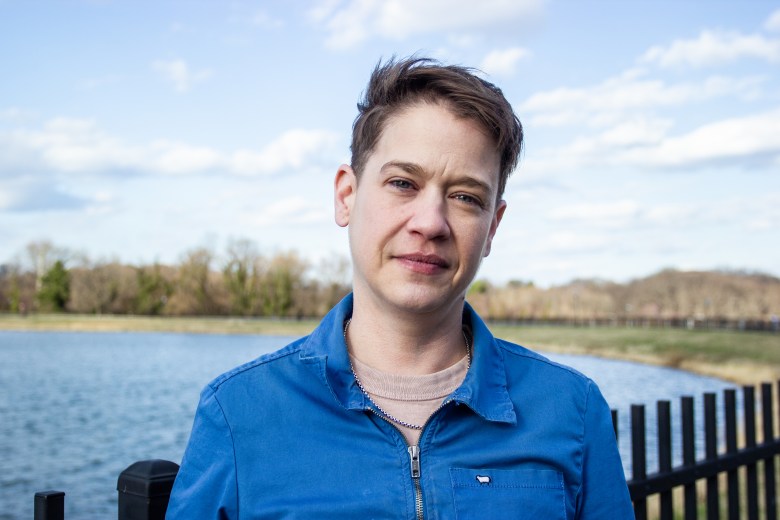 Jennie Egan poses in front of water wearing a blue shirt.