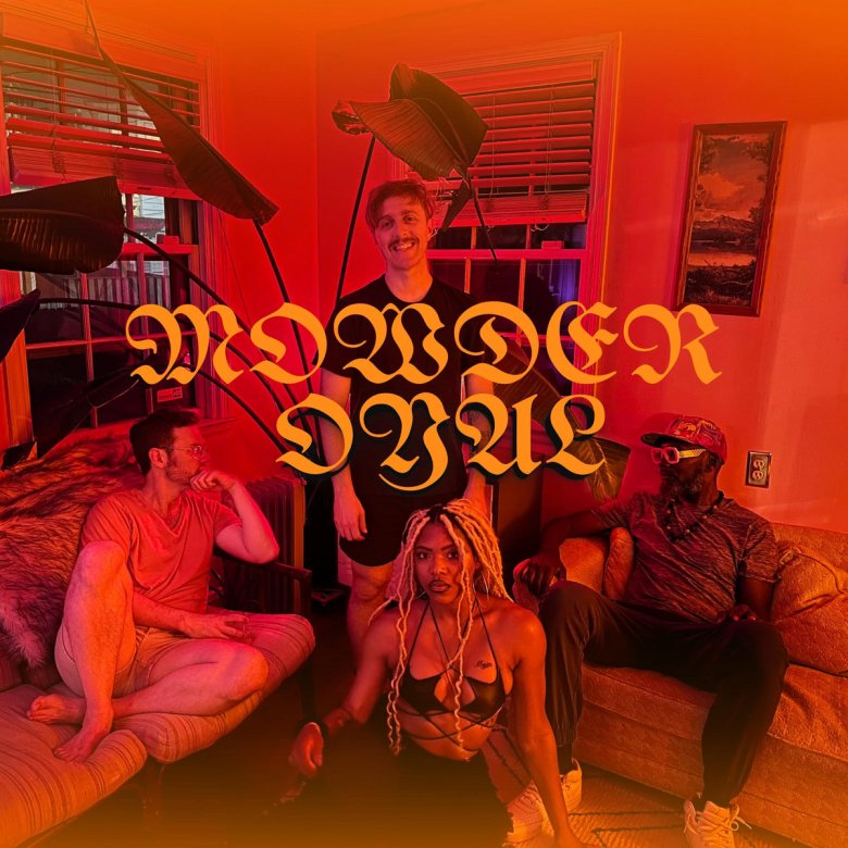 A photo of members of the band Mowder Oyal. Two people sit down on couches, one person stands, and one person sits on the floor. They are in a room that is lit up red.
