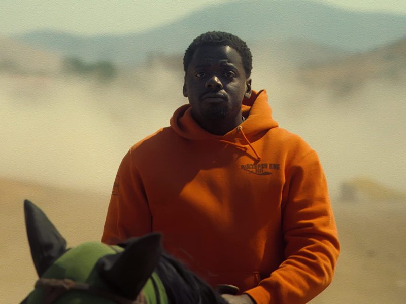 Daniel Kaluuya on horseback in an orange hoodie