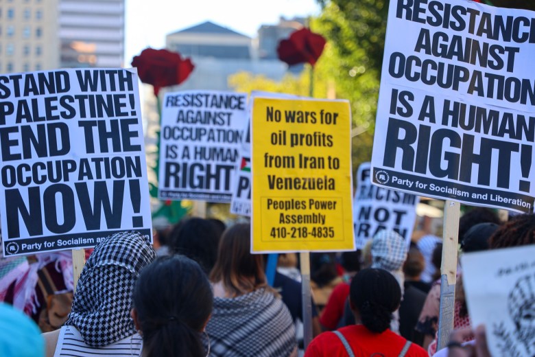 Protesters hold signs