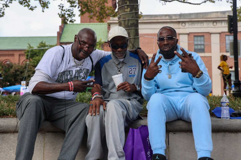 Three seated people pose for the camera
