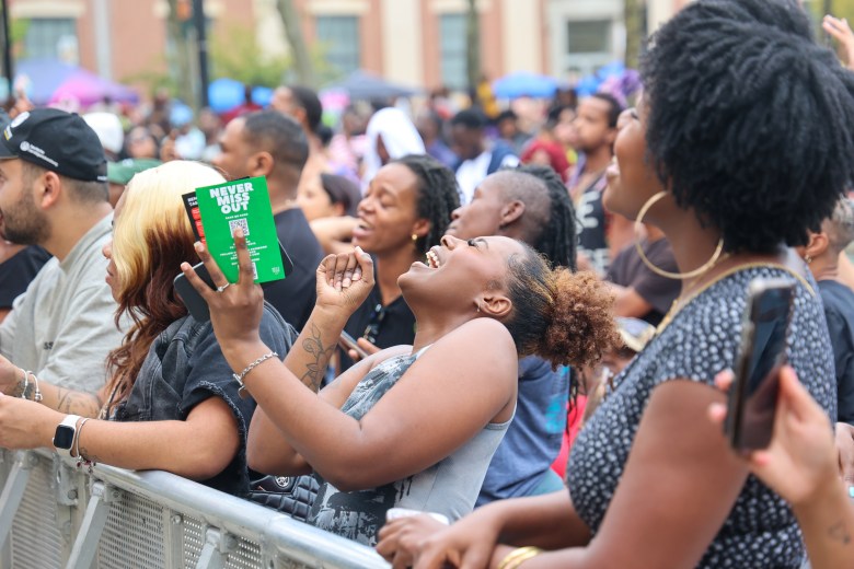 Crowd members laugh and sing.