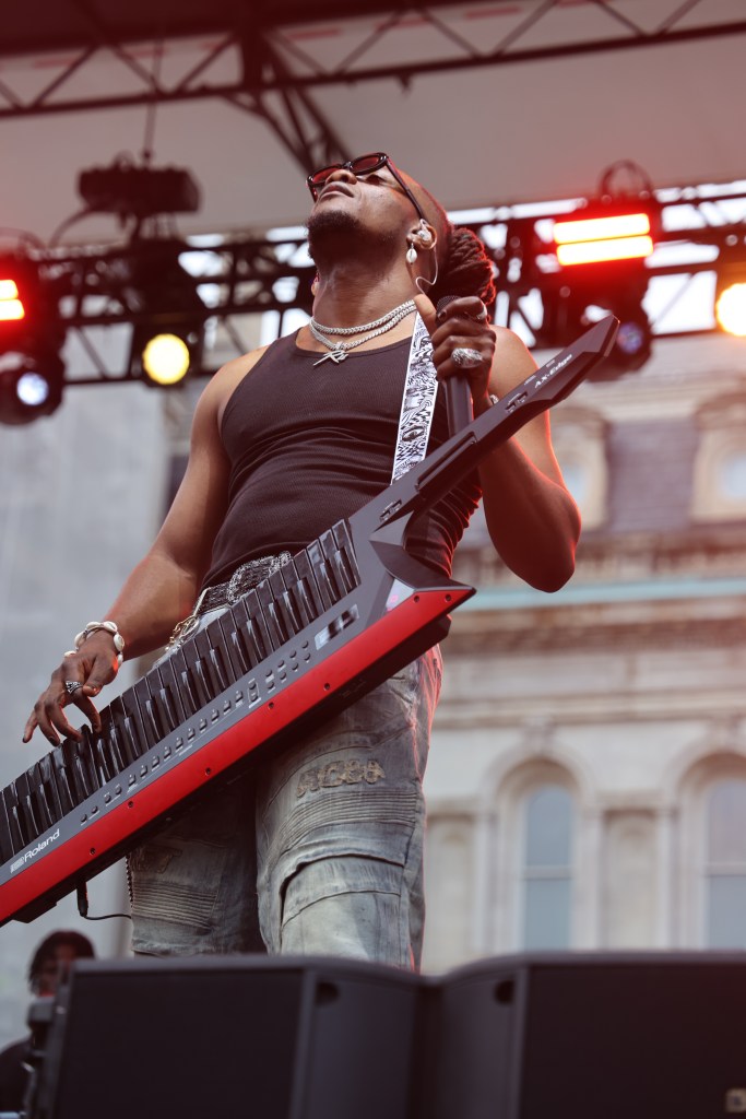 A man performs holding a keytar.