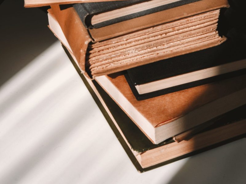 Brown and green hardbound books stacked together