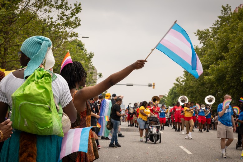 Parade viewers holding Trans Rights flags as the Baltimore Children and Youth Fund approaches.